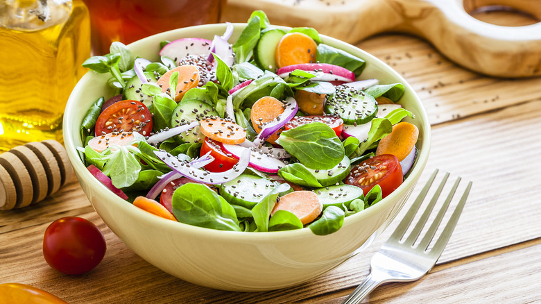 salad in a bowl next to a fork