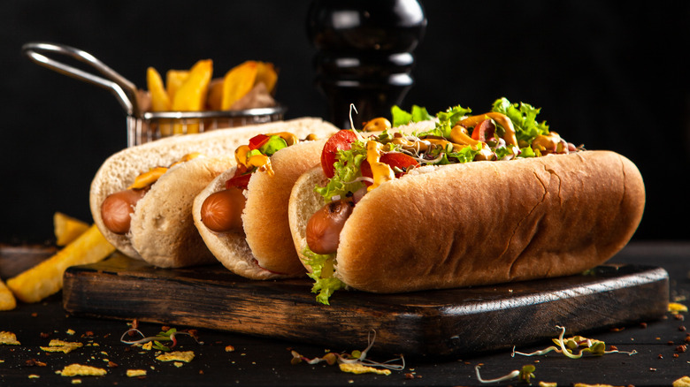 Three hotdogs on cutting board