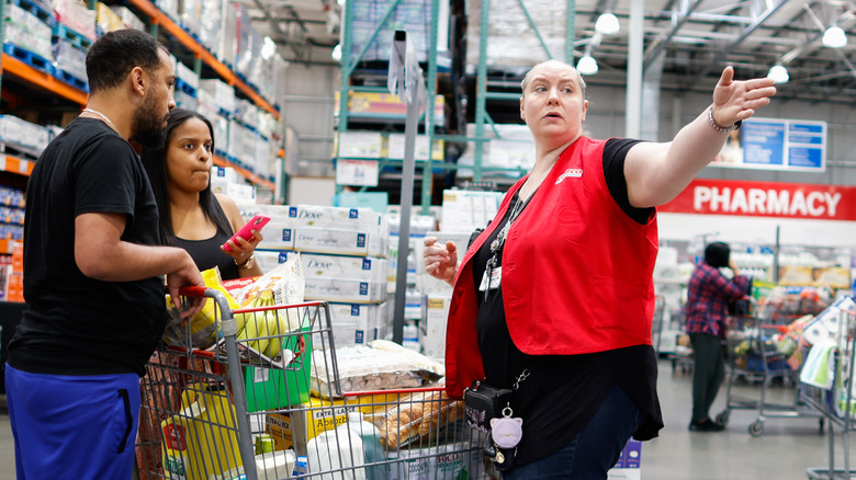 A Costco employee helps customers in store
