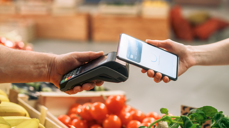 Person paying for groceries with their iPhone