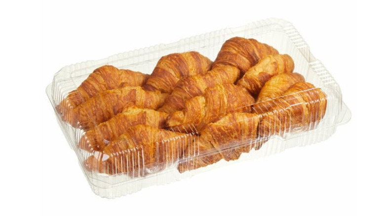 a clear plastic container full of croissants
