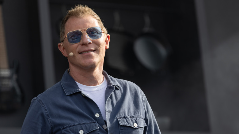 Celebrity chef Bobby Flay posing onstage with sunglasses.