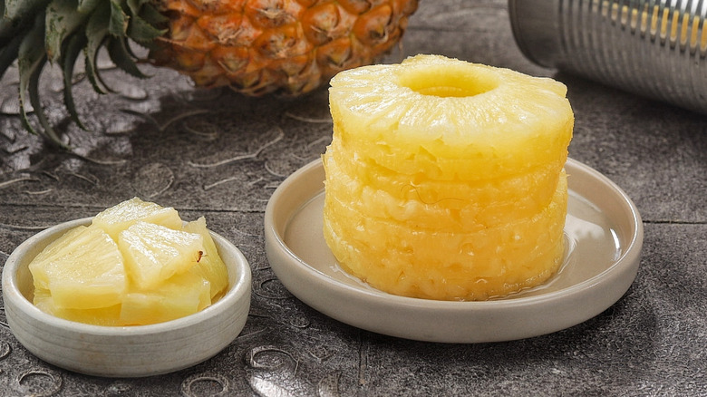 Canned pineapple slices in a plate with pieces on two plates next to each other