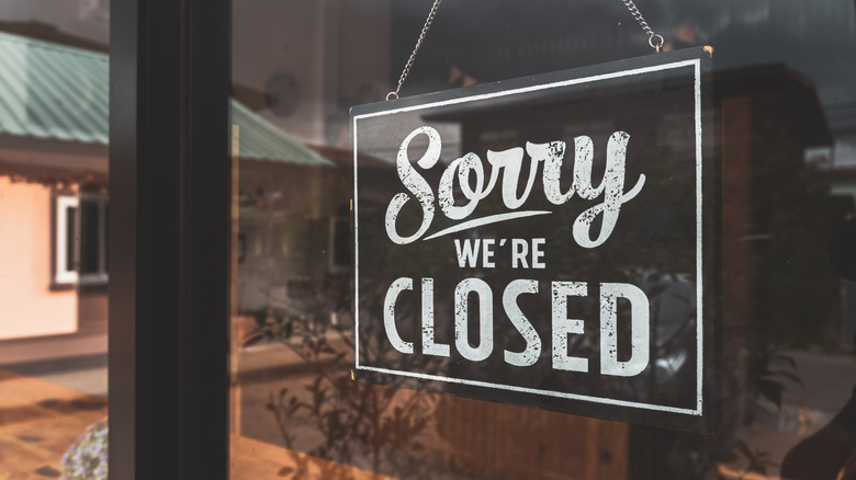 sorry we're closed signage hanging on door