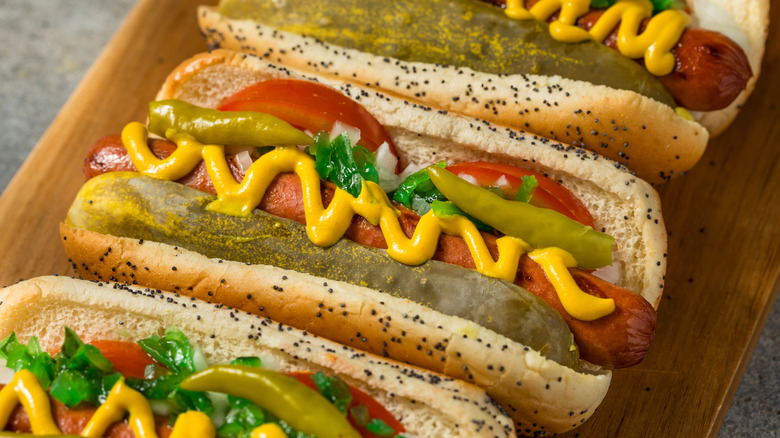 Close-up of Chicago-style hot dogs on cutting board