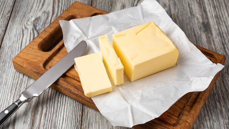 Block of butter on wooden chopping board