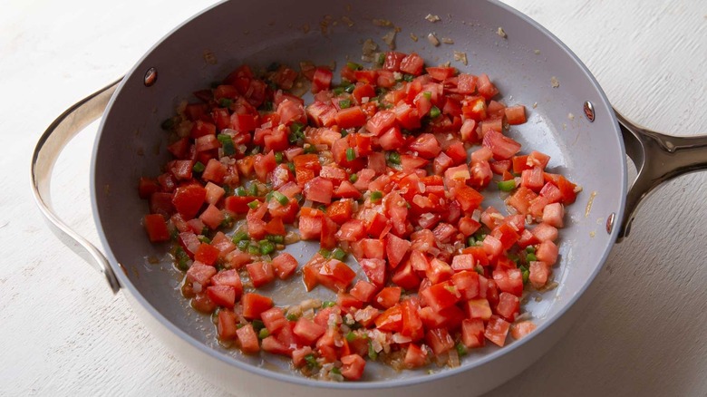 diced tomatoes sauteeing in skillet