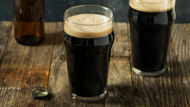 Glasses of dark beer on wooden table