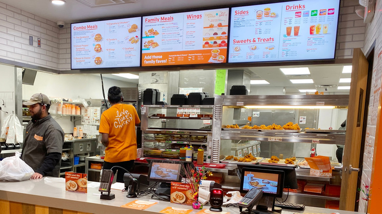 the interior of a Popeyes chicken counter and menu boards