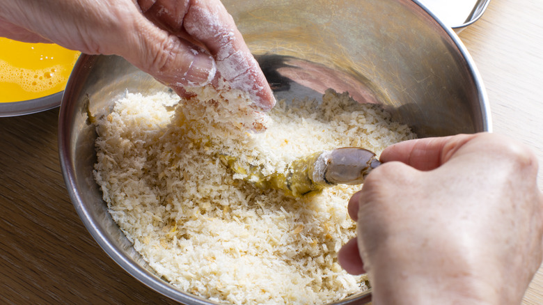 hands in bowl of breadcrumbs