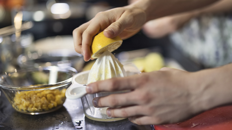 A person squeezing lemon juice.