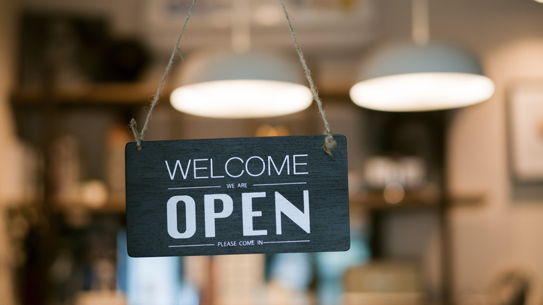open sign hanging on door of business