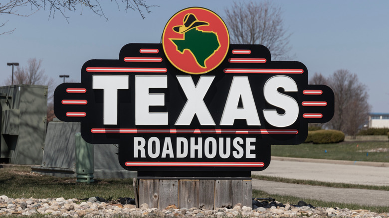 A standalone sign for Texas Roadhouse, with a silhouette of the state of Texas wearing a cowboy hat