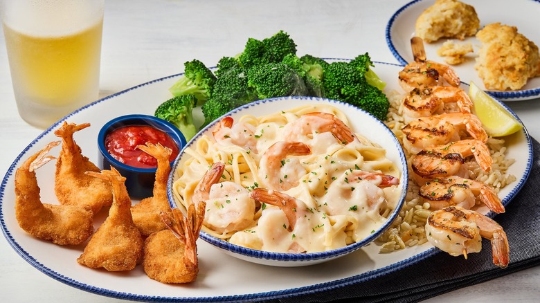 platter of seafood and broccoli with glass of beer