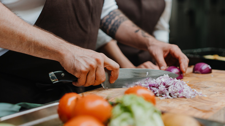 Chef knife slicing up an onion