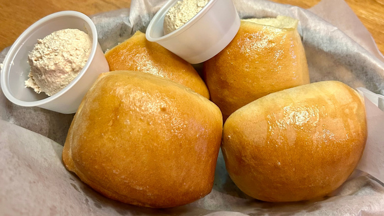 Texas Roadhouse rolls with cinnamon honey butter in a basket.