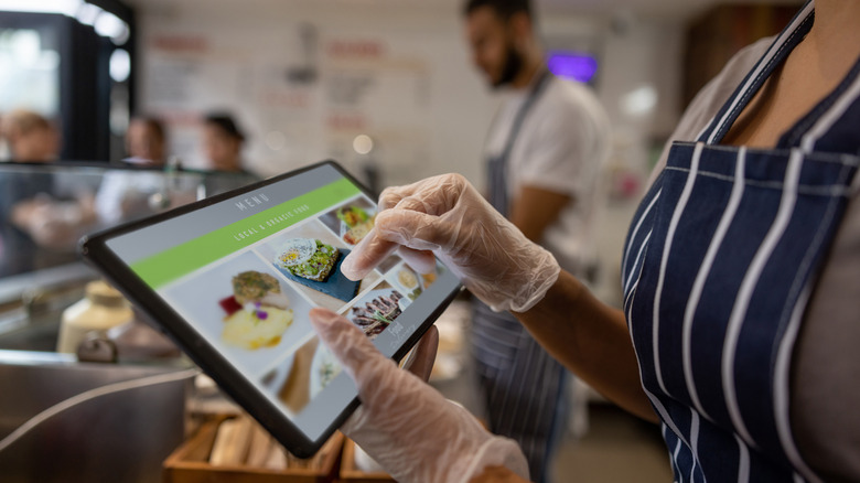 Restaurant servers hands putting an order into an iPad