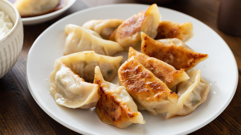 crispy golden brown homemade gyoza on a white plate