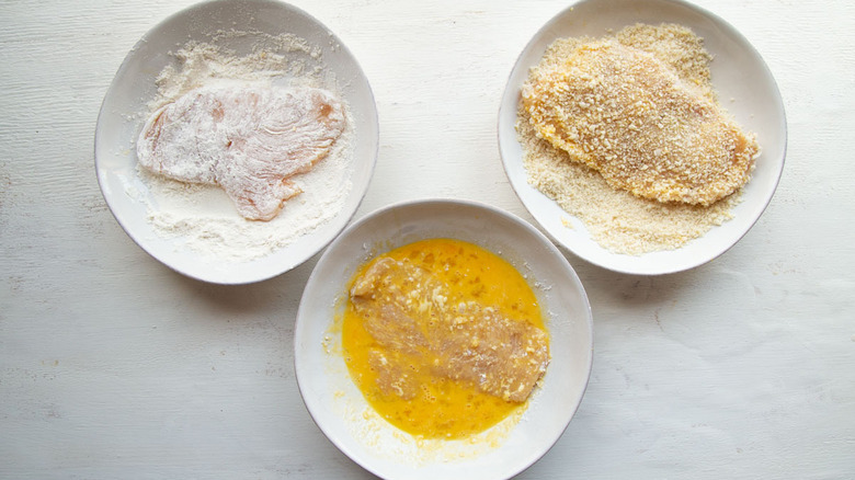 chicken immersed in flour, eggs, and breadcrumbs
