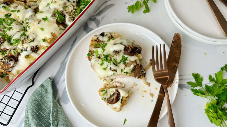 Chicken with mushrooms and cheese on a white plate
