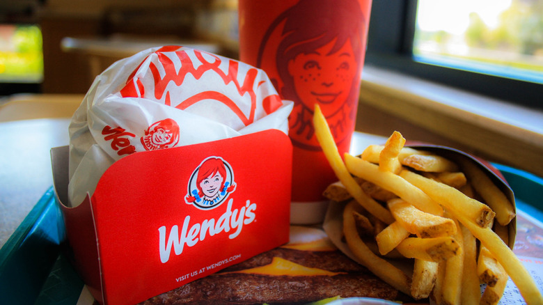 a meal at Wendy's with an unspecified sandwich in its packaging, french fries, and a drink