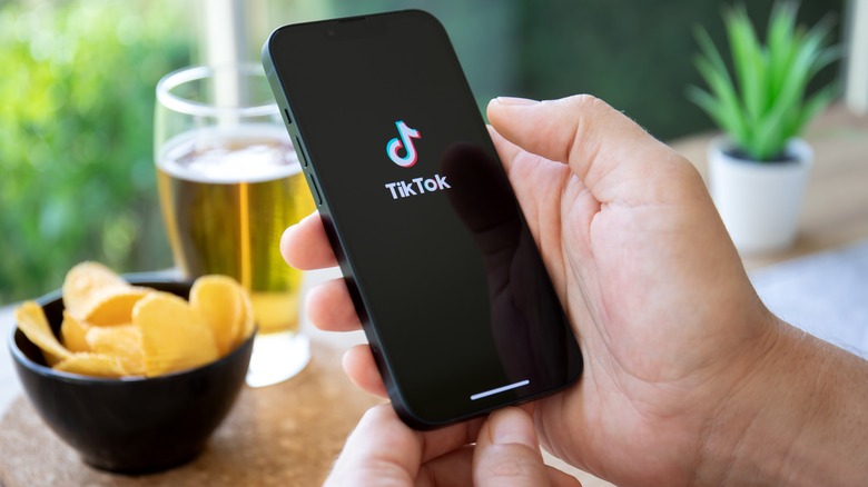 Phone in hand TikTok logo
