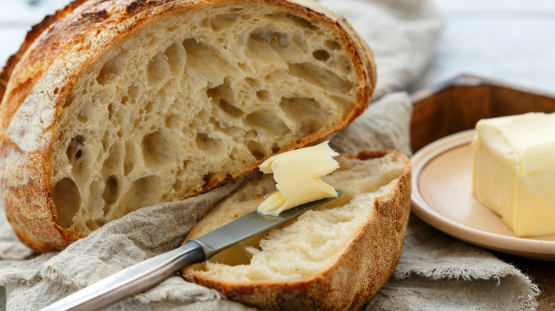 Knife with butter on top of a slice of bread