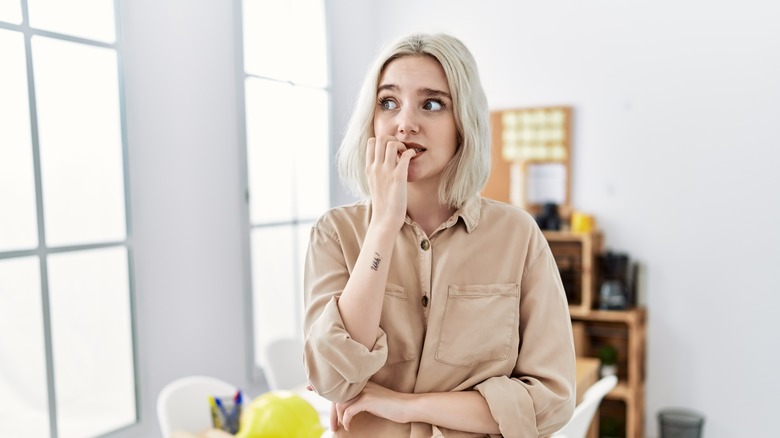 Woman anxiously biting nails