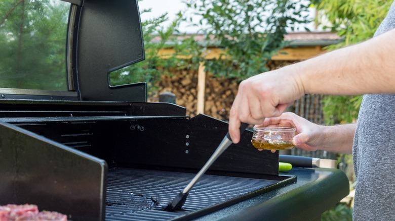 person oiling grill grates