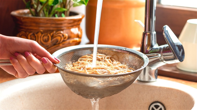 Rinsing soba noodles in strainer 