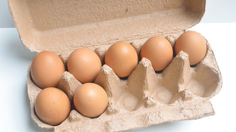 Open carton of brown eggs