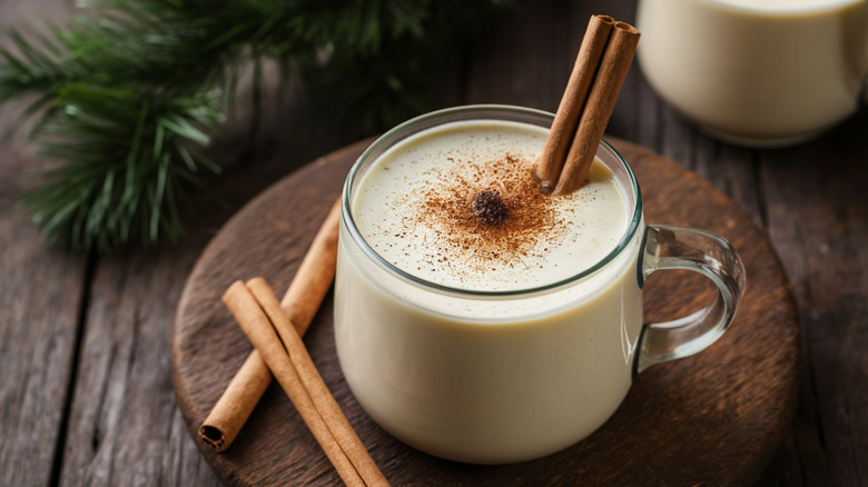 Homemade creamy cinnamon eggnog on a rustic wooden table.