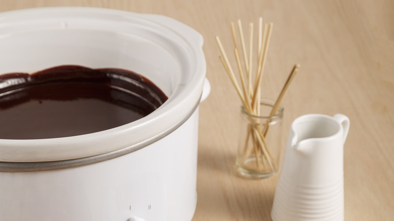 melted chocolate in crockpot with skewers