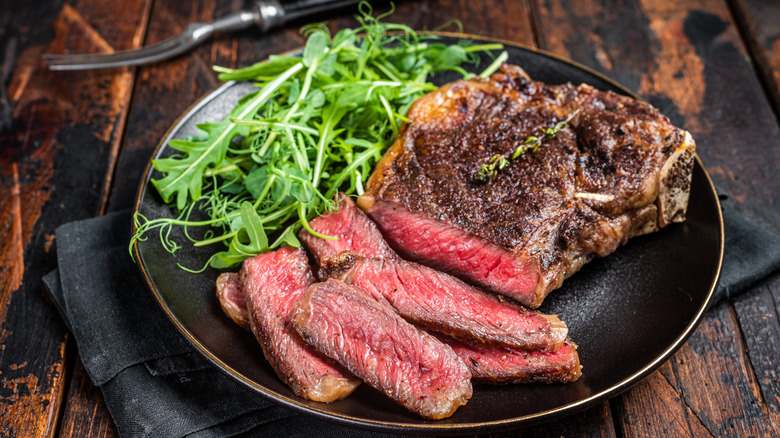 Sliced steak on plate with arugula