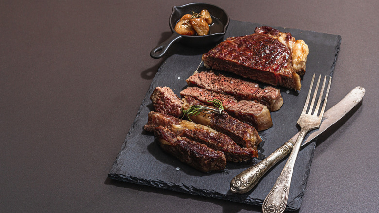 Well done sliced steak on black board