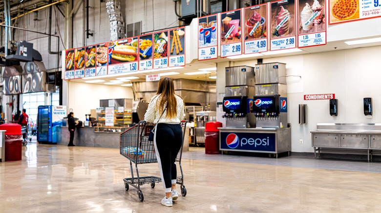 Costco shopper in front of food court menu
