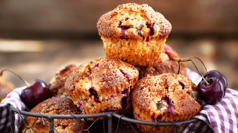 Wire bowl of cherry muffins with cherry garnish
