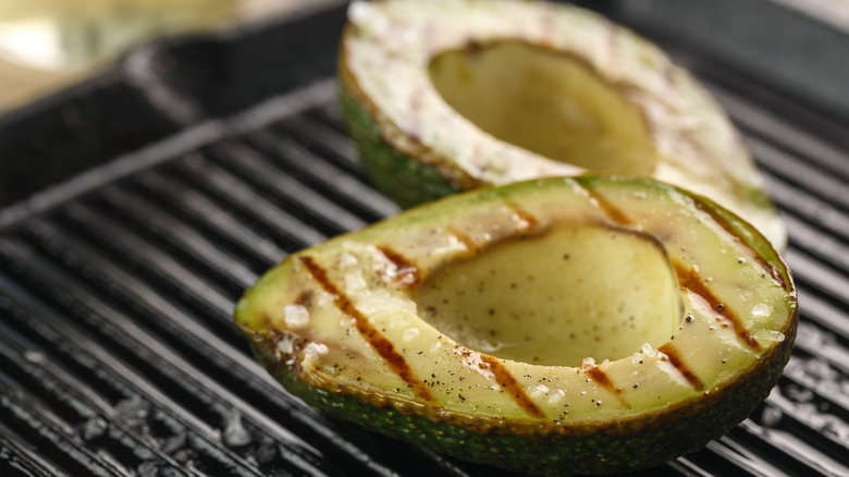 Avocado halves on grill