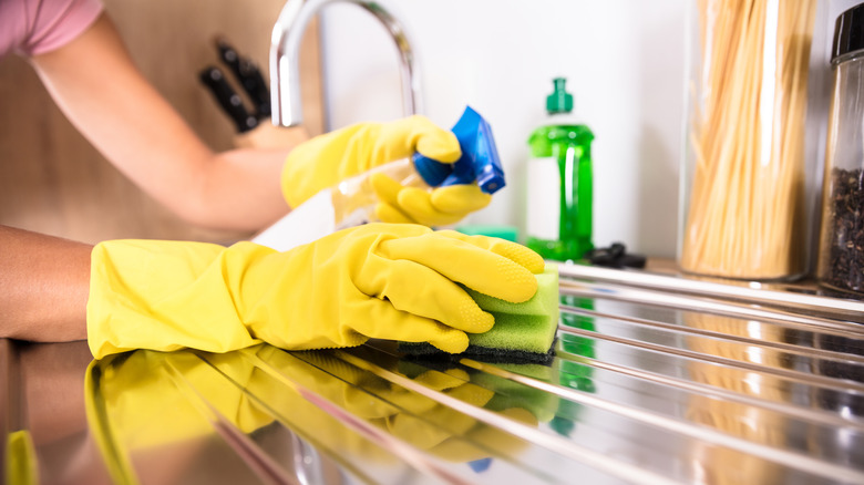 Someone cleaning a steel countertop