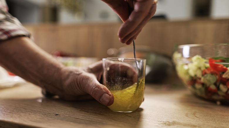 person mixing salad dressing