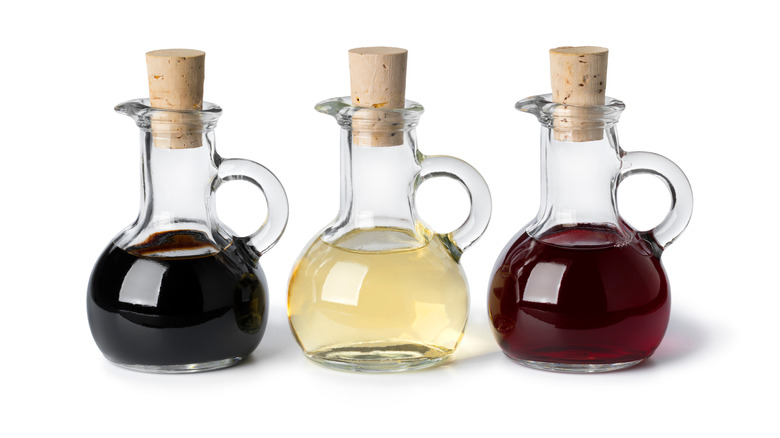 Three varieties of vinegar on white background