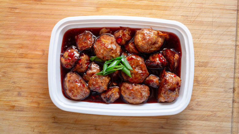 Grape jelly meatballs in a serving dish, with sauce