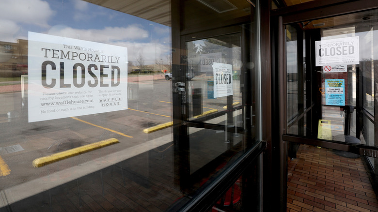 The exterior of a Waffle House with signs reading "temporarily closed"