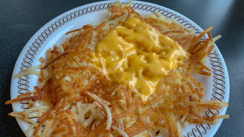 A plate of Waffle House hashbrowns with a slice of melted American cheese
