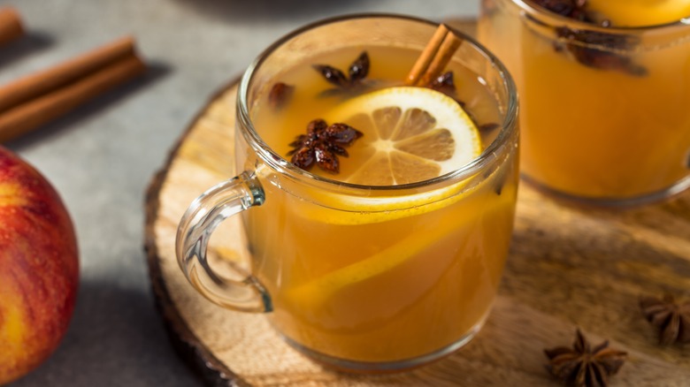Glass mug of wassail on wooden tray