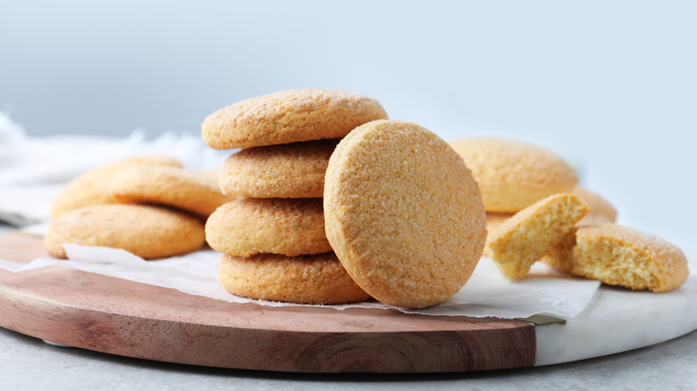 Stacked sugar cookies on a wooden board