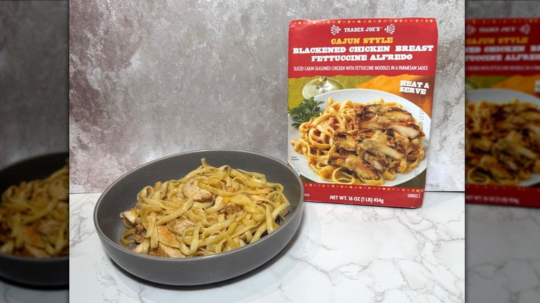 A bowl and box of Trader Joe's Cajun style blackened chicken breast fettuccine Alfredo