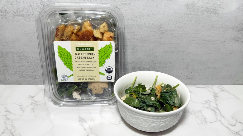 A container and bowl of Trader Joe's kale chicken salad