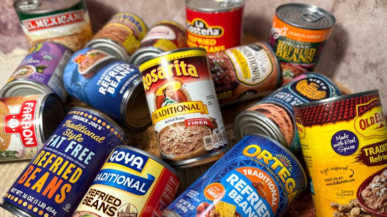 Pile of various cans of refried beans
