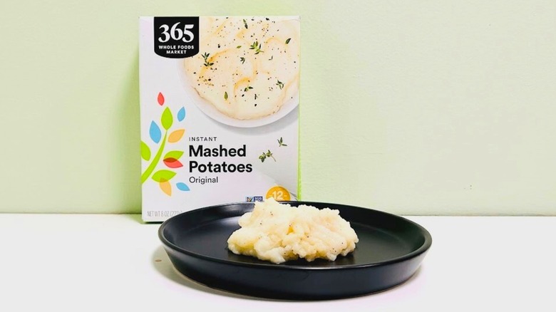 Plate of mashed potatoes in front of a box of 365 Whole Foods Market Instant Mashed Potatoes